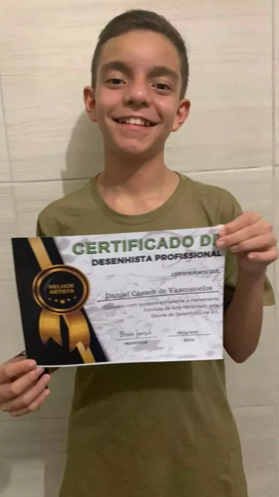 Criança sorrindo ao segurar o certificado de desenhista profissional que ganhou
