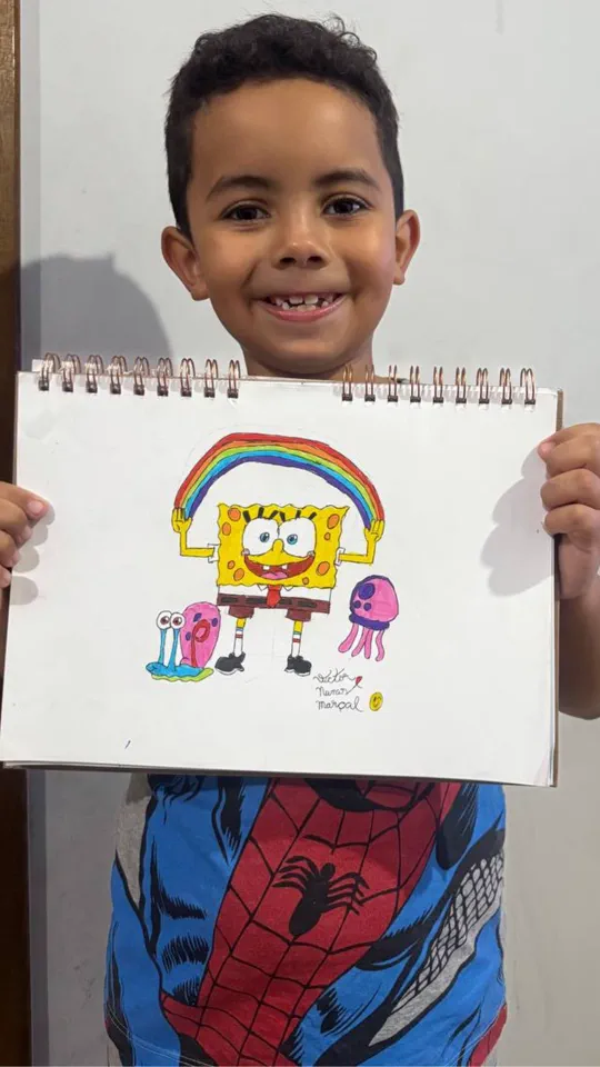 Criança orgulhosa mostrando o desenho que produziu na aula ao vivo do Clube Line Art