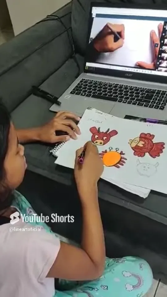 Aluna Isabel, 7 anos, desenhando em casa durante o encontro ao vivo, filmada pela mãe